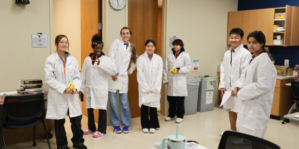 Forensic Science students smiling in lab coats
